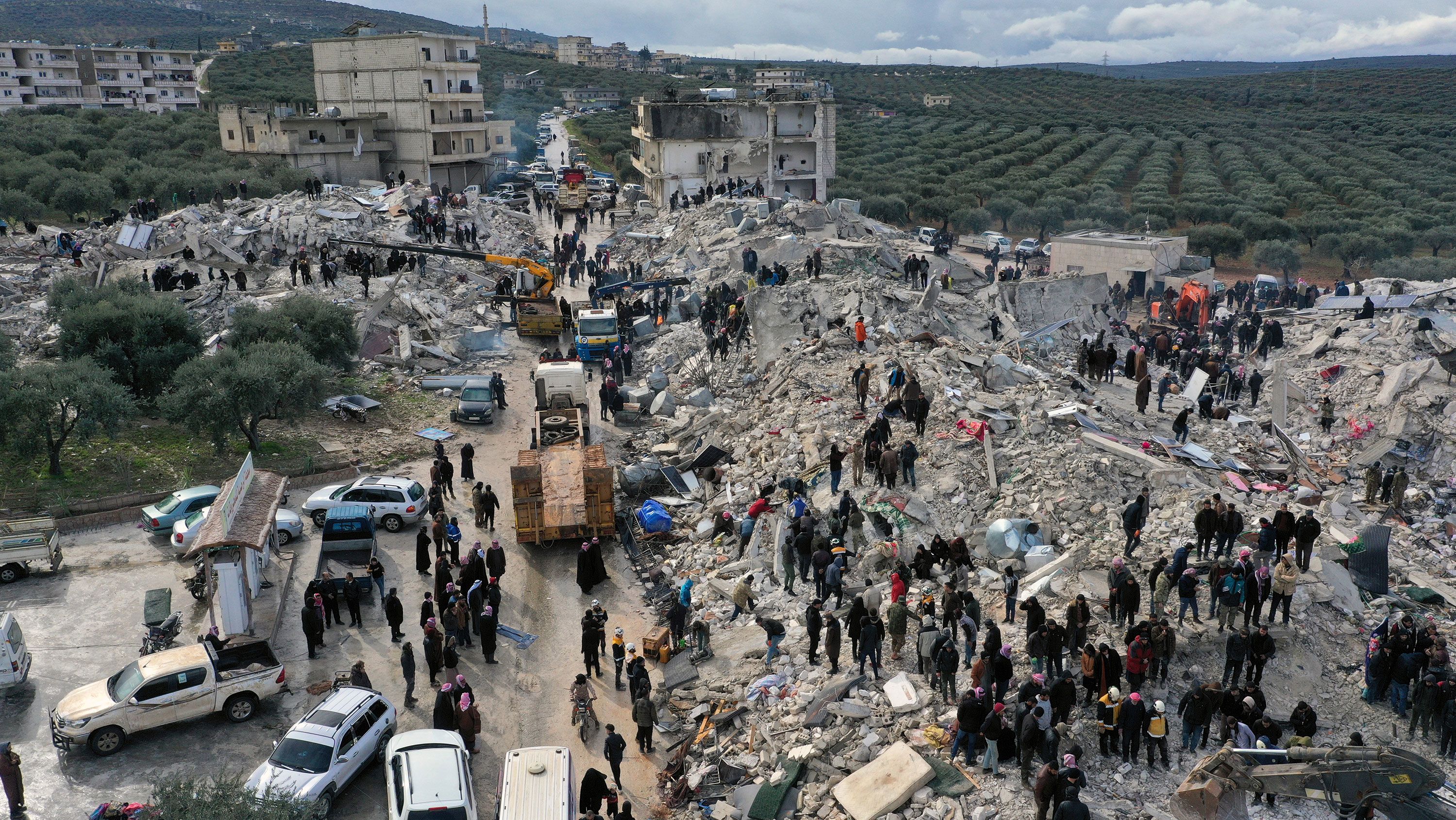 Residents search through the rubble of collapsed buildings near the Turkish border, Idlib province, Syria, Feb. 6, 2023.