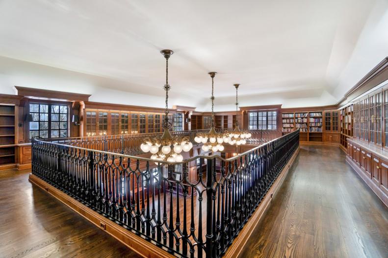 Library mezzanine with wrought iron railing and custom bookshelves.